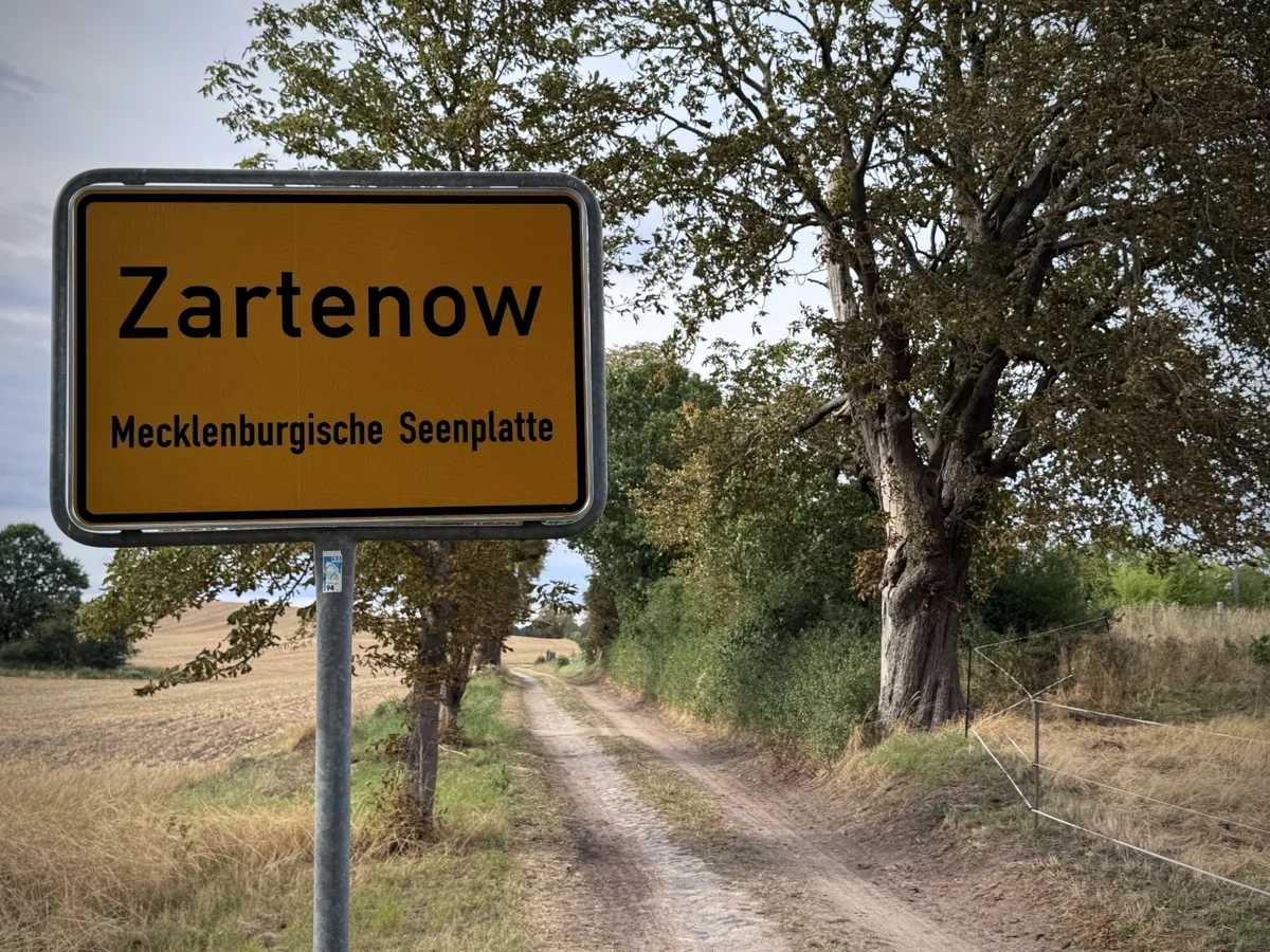 Das Ortsschild von Zartenow, dem Dorf aus dem Roman „Meisterwerk mit Kaltem Hund“, an einem Feldweg in Mecklenburg.